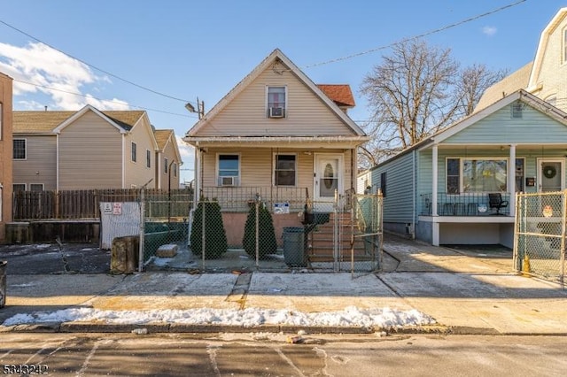 view of front of house featuring a fenced front yard, a porch, and a gate