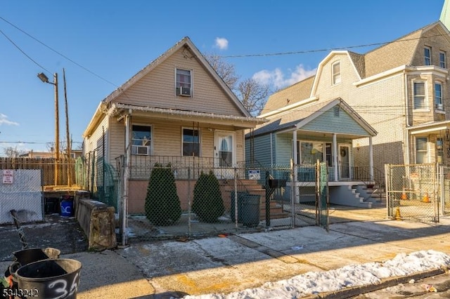 view of front facade with a gate, covered porch, and a fenced front yard