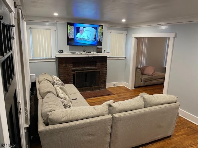 living area with recessed lighting, baseboards, wood finished floors, and a fireplace