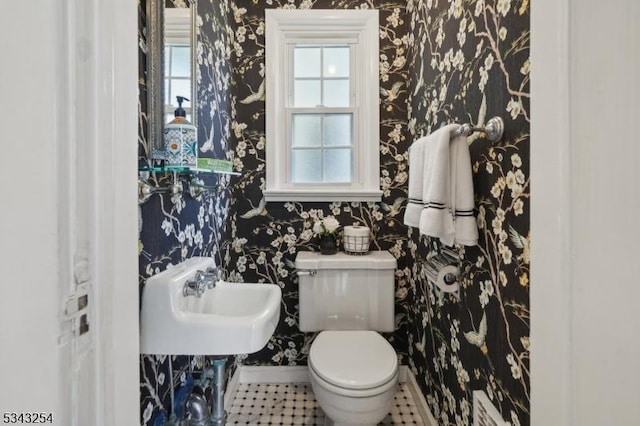 half bath featuring wallpapered walls, toilet, and plenty of natural light