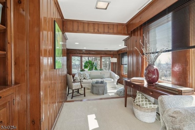 living area with carpet floors and wooden walls