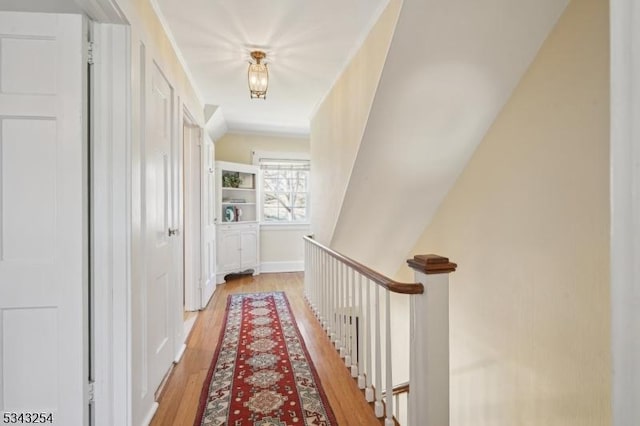 hallway with an upstairs landing and light wood-style flooring