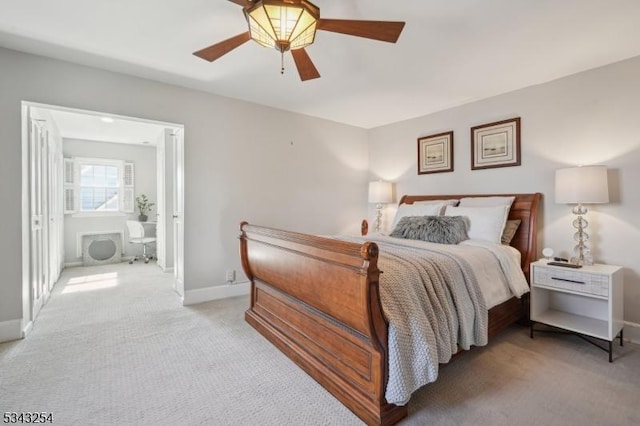 bedroom featuring light carpet, ceiling fan, connected bathroom, and baseboards