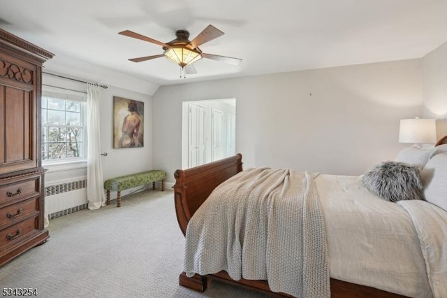 carpeted bedroom with radiator heating unit and a ceiling fan