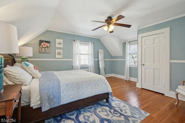 bedroom with vaulted ceiling, ceiling fan, baseboards, and wood finished floors