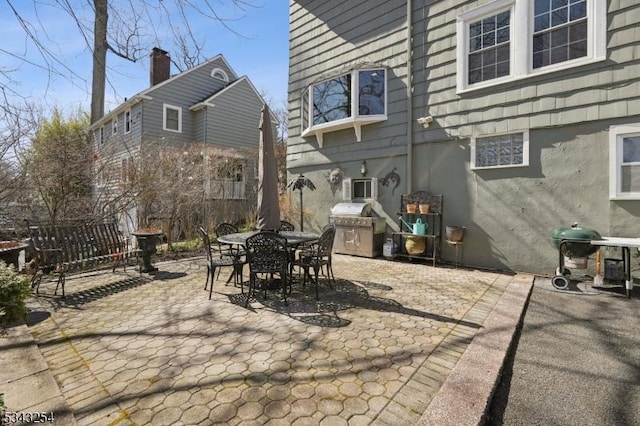 view of patio featuring a grill, outdoor dining area, and fence