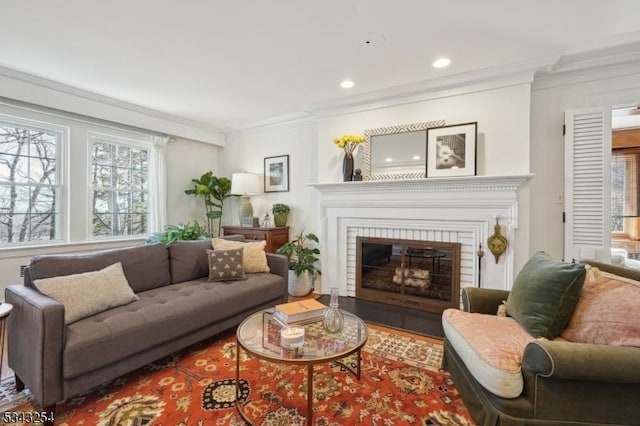 living room with recessed lighting, wood finished floors, ornamental molding, and a fireplace