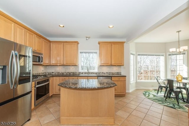 kitchen featuring light tile patterned floors, a sink, decorative backsplash, stainless steel appliances, and a center island