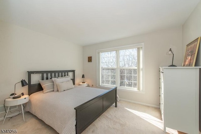 bedroom with light carpet and baseboards