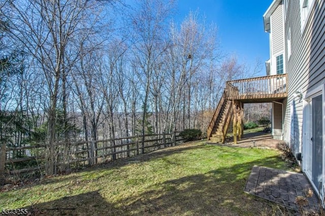 view of yard featuring stairs, a deck, and fence