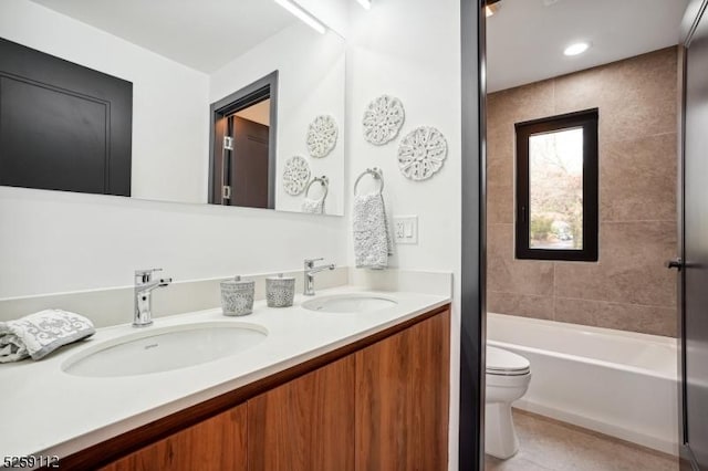 full bath featuring double vanity, toilet, a bathtub, and a sink