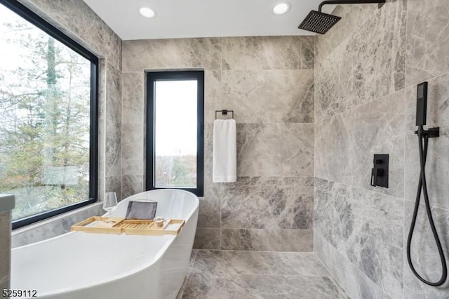 bathroom with tile walls, a freestanding tub, recessed lighting, and tiled shower