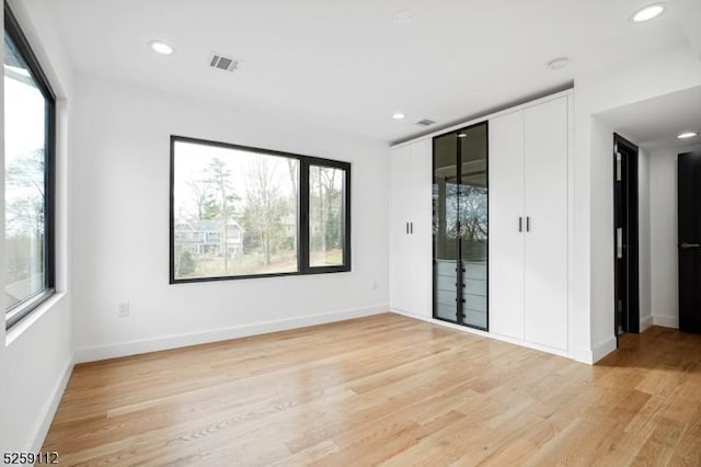 spare room with light wood finished floors, visible vents, recessed lighting, and baseboards