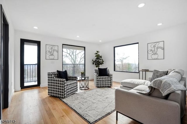 living area featuring recessed lighting, light wood-type flooring, and baseboards