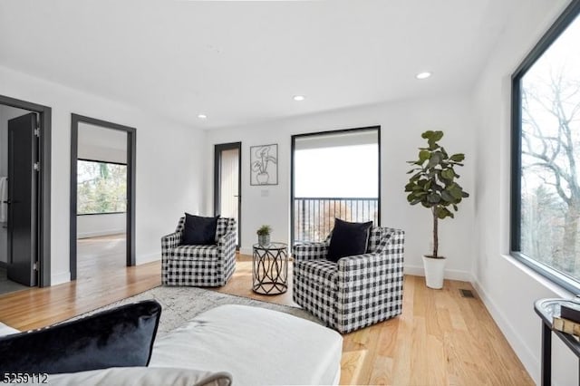 living area with recessed lighting, light wood-style floors, visible vents, and baseboards