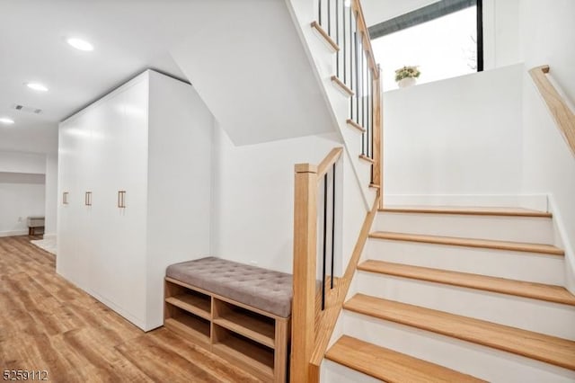 stairway featuring visible vents, recessed lighting, and wood finished floors