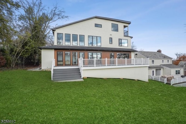 back of property featuring a lawn and a wooden deck