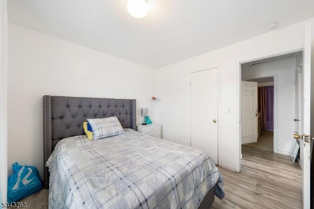 bedroom with baseboards and light wood finished floors