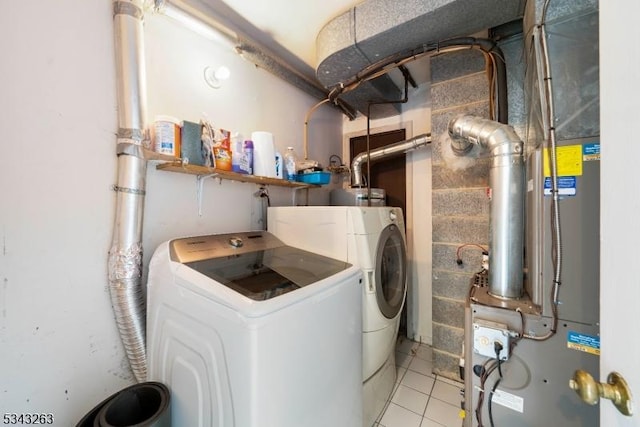 washroom featuring washer and dryer, laundry area, and light tile patterned flooring