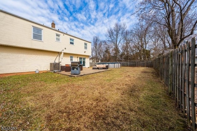 view of yard with a patio area, central air condition unit, and a fenced backyard