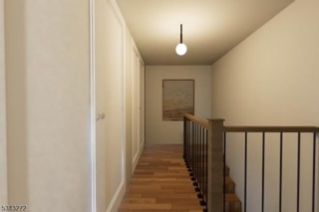 hall with an upstairs landing and light wood-style floors