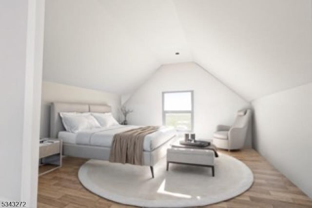 bedroom featuring lofted ceiling and wood finished floors