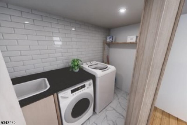 laundry area with washer and clothes dryer, laundry area, marble finish floor, and a sink