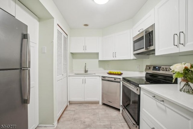 kitchen featuring a sink, stainless steel appliances, white cabinets, and light countertops