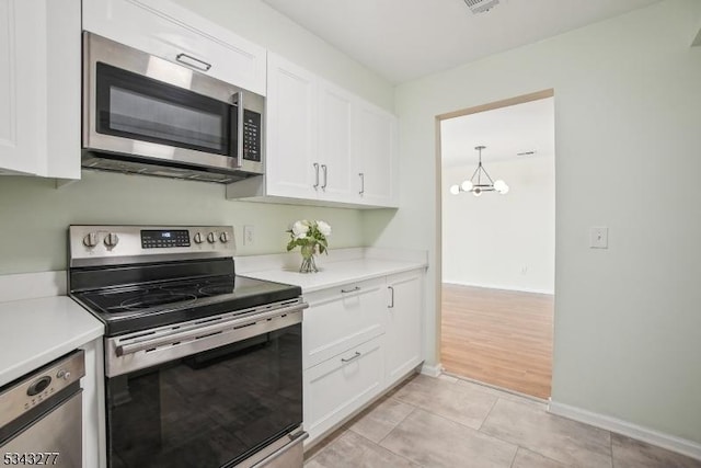 kitchen featuring light tile patterned flooring, appliances with stainless steel finishes, white cabinetry, and light countertops