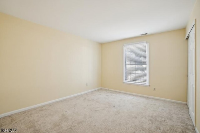 unfurnished bedroom featuring a closet, visible vents, baseboards, and carpet floors