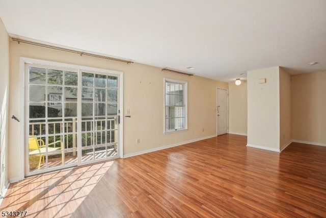 unfurnished room with baseboards and wood finished floors