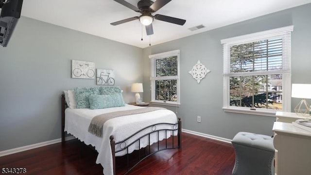 bedroom with visible vents, baseboards, and wood finished floors