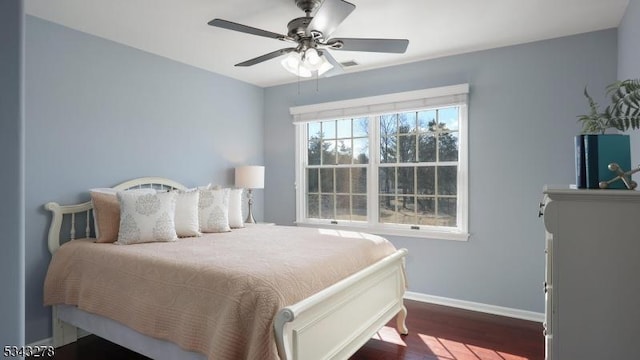 bedroom with visible vents, a ceiling fan, baseboards, and wood finished floors