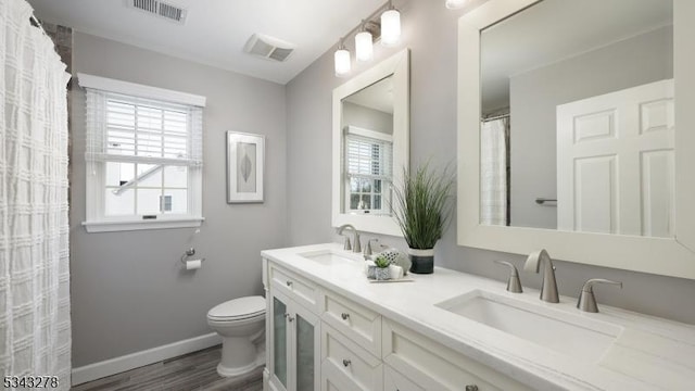 bathroom featuring toilet, visible vents, and a sink