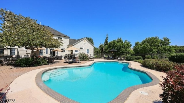 view of swimming pool featuring a fenced in pool, fence, and a patio area