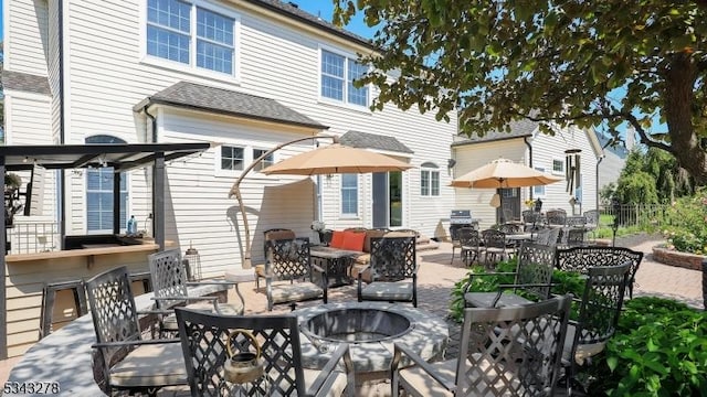 view of patio with an outdoor fire pit and fence