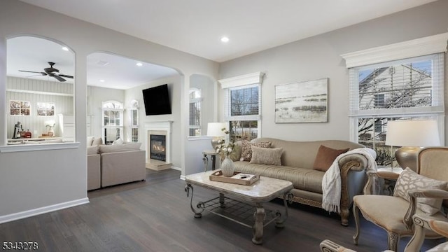 living room with baseboards, ceiling fan, recessed lighting, wood finished floors, and a glass covered fireplace