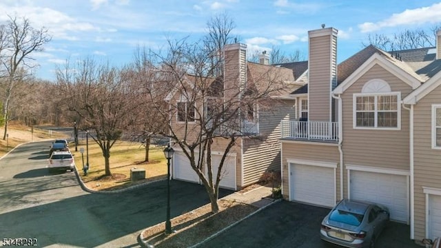 view of home's exterior featuring a garage and a chimney