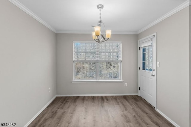 unfurnished dining area featuring wood finished floors, baseboards, an inviting chandelier, and ornamental molding