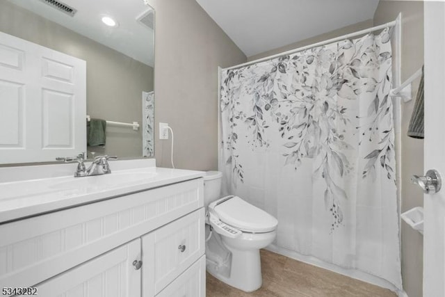 bathroom featuring visible vents, toilet, wood finished floors, a shower with shower curtain, and vanity