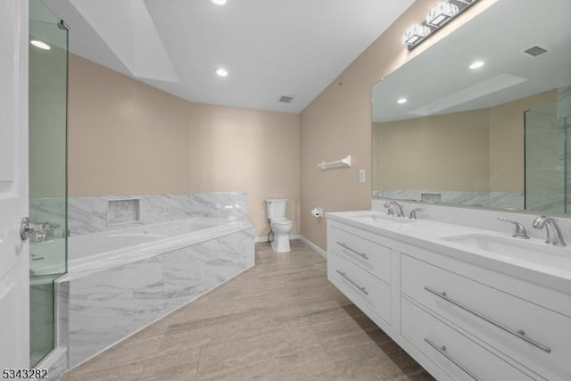 full bathroom with a sink, a garden tub, double vanity, and toilet