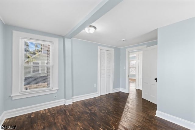 spare room featuring baseboards and wood finished floors