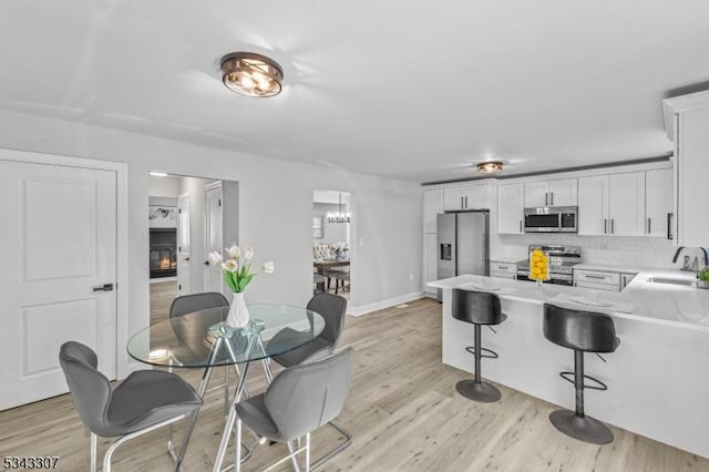 kitchen featuring a sink, light wood-type flooring, appliances with stainless steel finishes, and light countertops