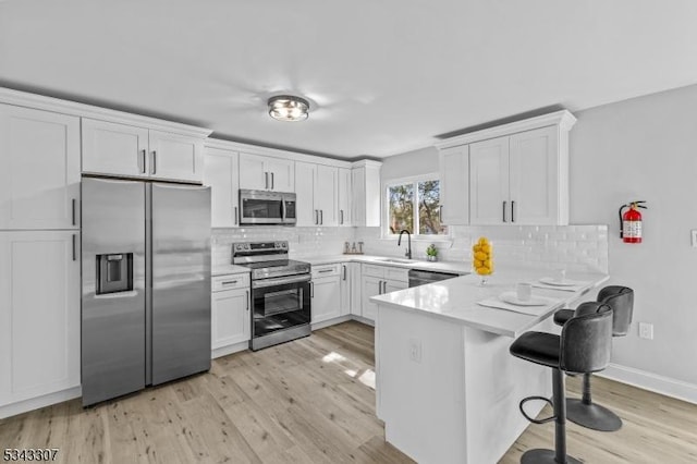 kitchen with white cabinetry, a peninsula, and appliances with stainless steel finishes