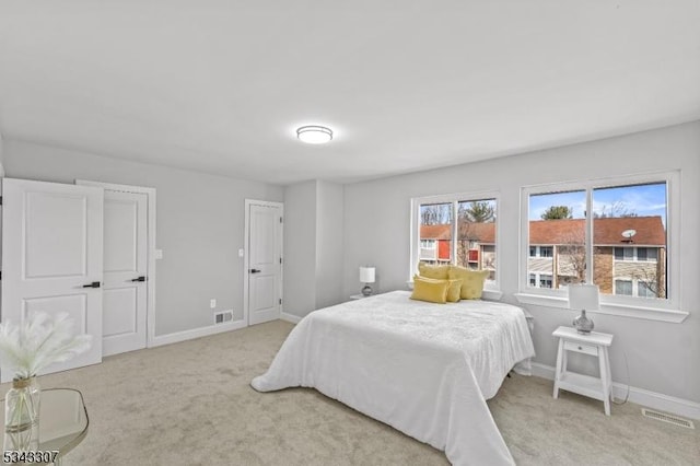 bedroom featuring light carpet, visible vents, and baseboards