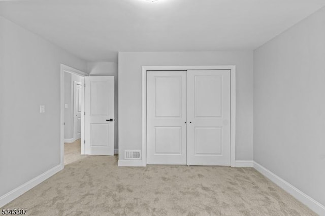 unfurnished bedroom with a closet, visible vents, baseboards, and carpet floors