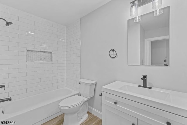 full bath with baseboards, toilet, shower / bath combination, wood finished floors, and vanity