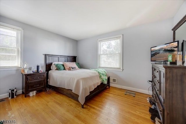 bedroom with visible vents, baseboards, and light wood-style flooring