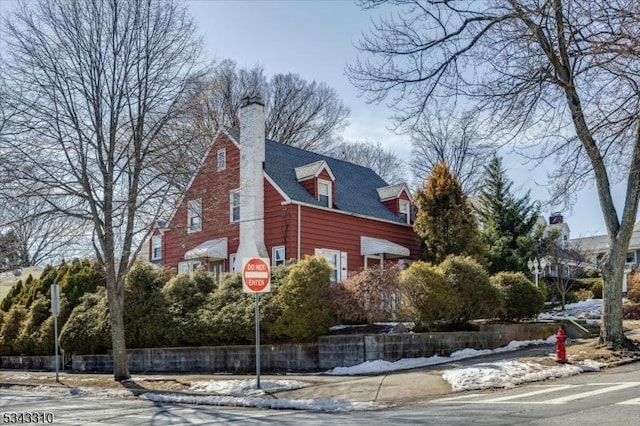 snow covered property with a chimney