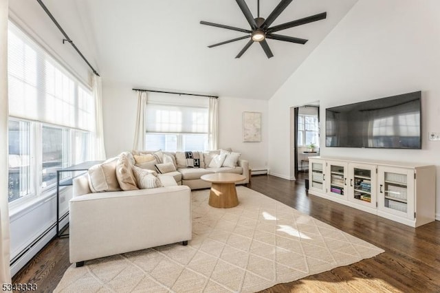 living area featuring baseboard heating, high vaulted ceiling, a ceiling fan, and wood finished floors